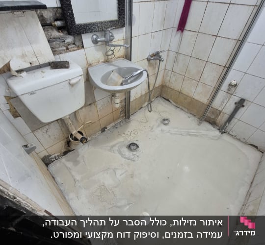 חדר אמבטיה עם קירות מתקלפים ורצפה רטובה